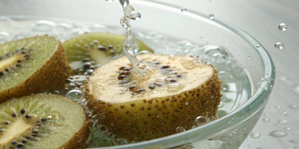 A macro shot of swollen chia seeds suspended in water, highlighting their gelatinous texture and translucent outer layer.